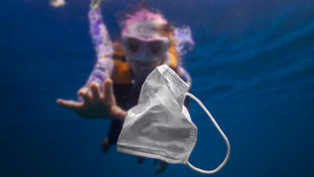 diver cleaning up the ocean grabbing a mask floating in the water